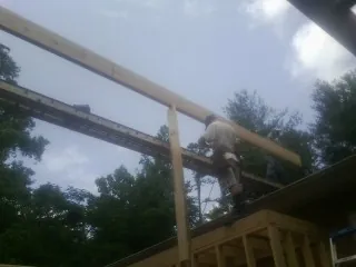 Carpenter setting a ridge beam over a new addition frame — Ice Dam Removal by Roofing Brothers in Idabel