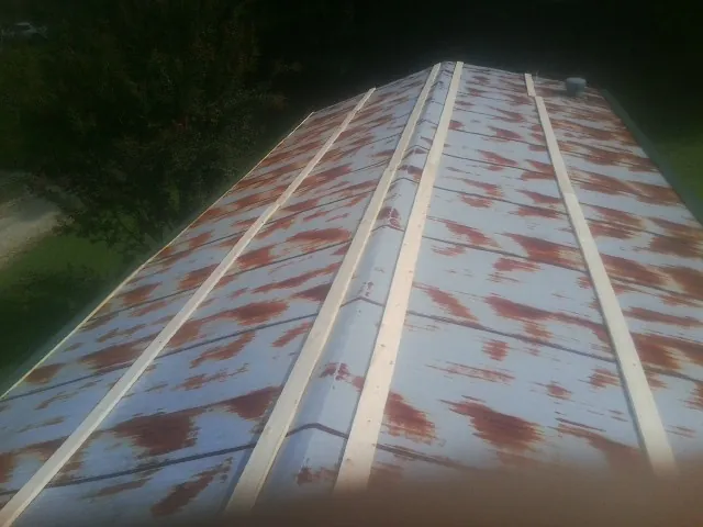 Rusted metal roof panels with new wood purlins before replacement — Storm Damage Roof Repair in Idabel by Roofing Brothers