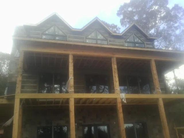 Dormers and porch framing on a large log home under construction — Roof Coating work by our crew in Idabel