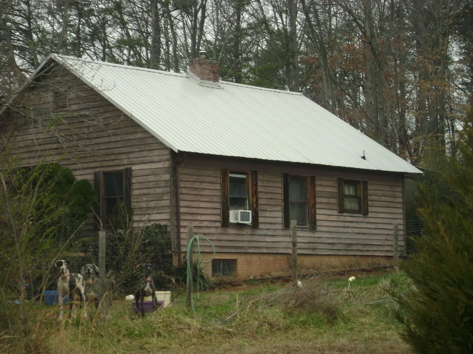 White metal roof on an old wood sided farmhouse, from a Asphalt Shingle Roof Repair job in Idabel